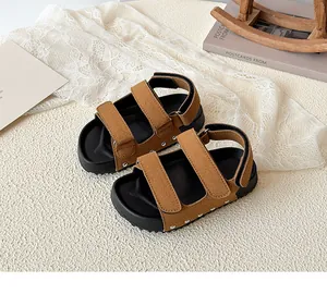 Detail of brown velcro sandals showing suede texture, thick soles and silver rivets decoration