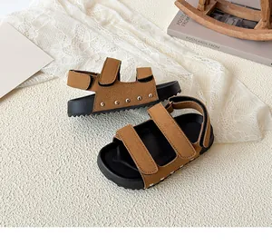 Detail of brown suede children sandals with hook-and-loop straps and thick serrated soles