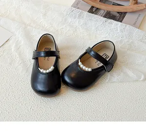 Détail de chaussures Mary Jane en cuir verni noir avec élégante lanière de perles