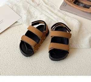 Detail view of tan faux suede kids sandals with velcro straps and silver metal studs