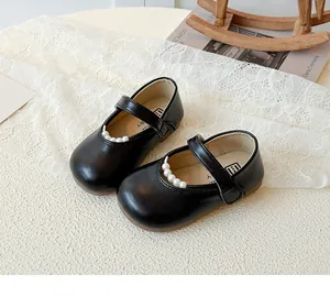 Détail de chaussures Mary Jane noires pour filles avec perles décoratives sur bride