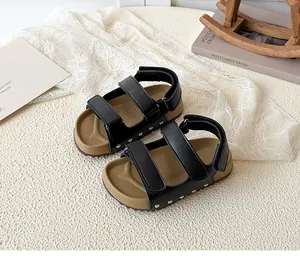 Close-up of kids open-toe sandals with dual velcro straps and silver rivet details