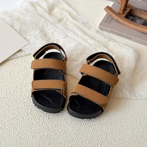 Brown open-toe kids sandals with magic tape straps and non-slip thick black soles