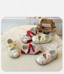 Detailed view of girls Mary Jane flats with crisscross straps and bow tie accents