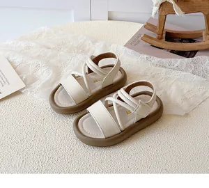 Detail of girls' cream faux leather sandals with crisscross straps and brown platform sole