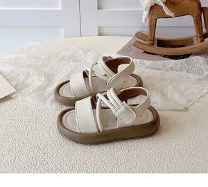 Detail view of cream children's sandals featuring velcro straps and thick cushioned soles
