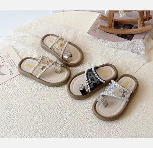 Détail de sandales à paillettes pour filles avec brides en perles et fleurs en strass