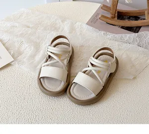 Close-up of girls beige strappy sandals with thick brown soles on a lace background