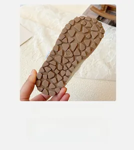 Detailed close-up of non-slip rubber sole with triangle patterns and size 27 mark on kids shoe