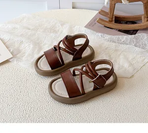 Macro detail of brown leather girls sandals with silver metal buckle and rubber sole