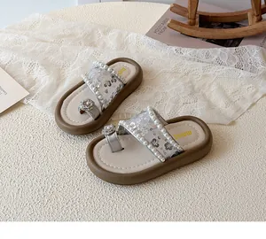 Détails de fleurs scintillantes et perles sur des sandales argentées pour filles