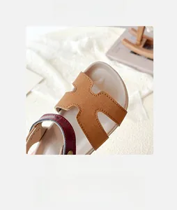 Detail shot of hollow H-cut strap kids sandals with contrasting red band and open toe