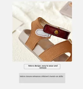 Detailed close-up of brown suede children sandal with velcro strap and metal buckle