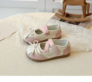 Detail of baby Mary Jane shoes featuring pearl white pink stitching and bow decoration