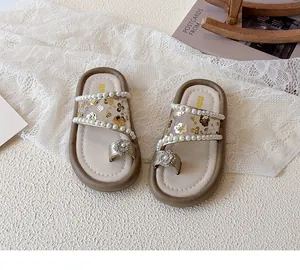 Détail de sandales pour filles avec paillettes, perles et accents floraux en diamant