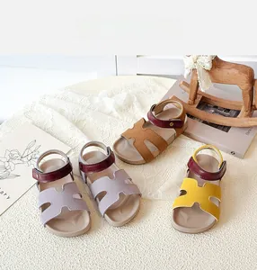 Macro detail of children's cut-out sandals in purple, yellow, and tan leather