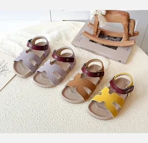 Detailed view of kids hollow H-strap sandals in purple, brown and yellow colors