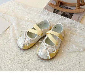 Detail of yellow and white kids Mary Jane shoes with bow and elastic straps