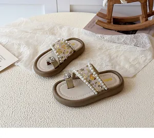 Détail de sandales pour filles avec fleurs à paillettes et décorations de perles blanches