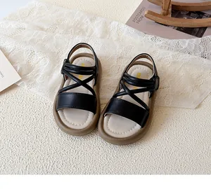 Detailed top view of black leather children's sandals with stylish cross-strap design