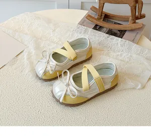 Detail showing silver and yellow Mary Jane shoes with bow decoration and elastic straps