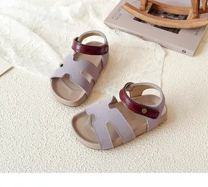 Detail of kids open-toe leather sandals with purple straps and maroon velcro fastening