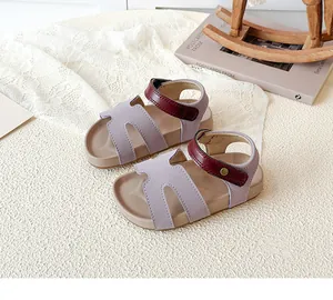 Detail of lavender and red girls' beach sandals with velcro strap on a rustic background