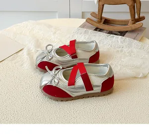 Detail of silver and red girls Mary Jane sneakers with ribbon bow and rubber sole
