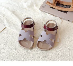 Detail of purple H-cut straps and crimson ankle strap with gold buckle on kids sandals