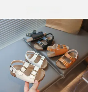 Détail de sandales enfant à double bride en blanc, noir et kaki avec semelle liège