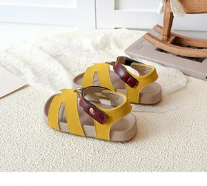 Detail of yellow and maroon hollowed-out children's sandals with ankle strap