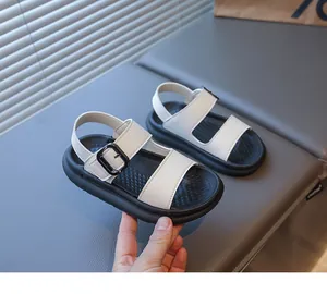 Dettaglio di sandali in pelle per bambini con suole antiscivolo nere e fibbie bianche