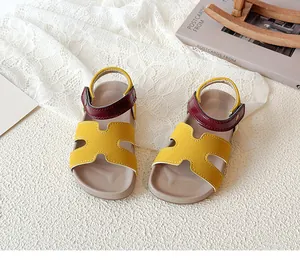 Detail of children's H-cut sandals featuring yellow vamp and burgundy leather heel strap
