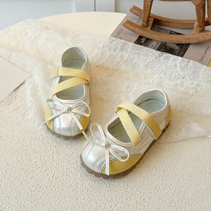 Silver Mary Jane shoes for girls with yellow straps and bow tie on lace background