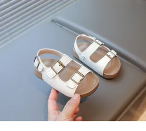 Gros plan détaillé de sandales en cuir blanc pour enfants avec trois boucles en bronze