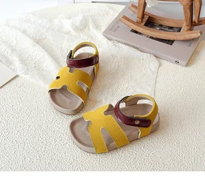 Close-up of yellow children's open-toe sandals with burgundy hook and loop fastener