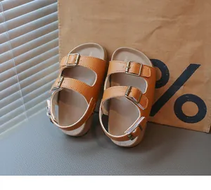 Gros plan de sandales en cuir marron pour enfants avec boucles et semelles souples