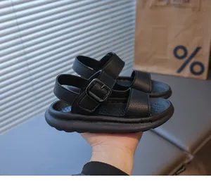 Dettaglio del sandalo nero per bambini con suola spessa in gomma e cinturino laterale