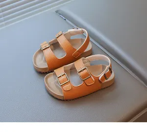 Détail de sandales brunes pour enfants avec semelle en liège et boucle réglable