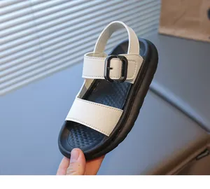 Dettaglio di sandali in pelle bianca per bambine con suole spesse in gomma nera e fibbie