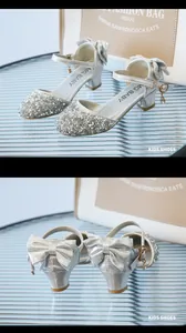 Detail von silbernen Pailletten-Prinzessin-Schuhen mit großer Schleife und Fesselriemen