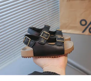 Détail de sandales noires pour enfants avec double sangle réglable et semelle en liège