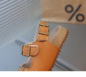Détail de sandales en cuir pour enfants avec boucles en laiton et semelle en gomme épaisse
