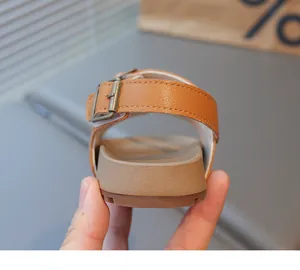 Détail d'une sandale marron pour enfant avec boucle métallique réglable et semelle épaisse