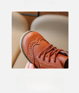 Close-up of brown leather children boots with vintage brogue carving and round toe detail