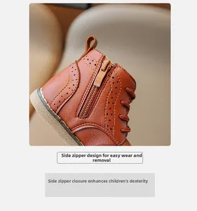 Detail of side zipper and Brogue carvings on brown leather kids' boots for easy wearing