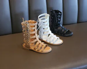 Detail of girls' high-top Roman sandals in khaki, white and black colors
