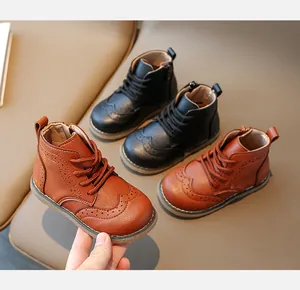 Detail of Brogue style kids leather boots with zipper and carved floral patterns