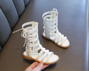 Detail of white girls' gladiator sandals featuring vertical zipper and multi-strap design