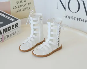 Detail of white high-top Roman sandals with cross laces and inner zipper for girls